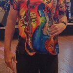 Bill in loud shirt (music theme) orange/red background with multiple colors